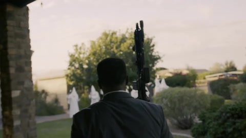 Jerone Davison holding an AR-15 as he faces off against home invaders